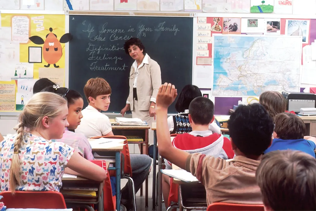 School administrator reviewing parent-teacher messages on a tablet in a small school office